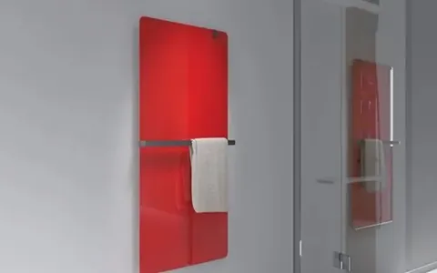 A red glass radiant wall heater with a towel rail