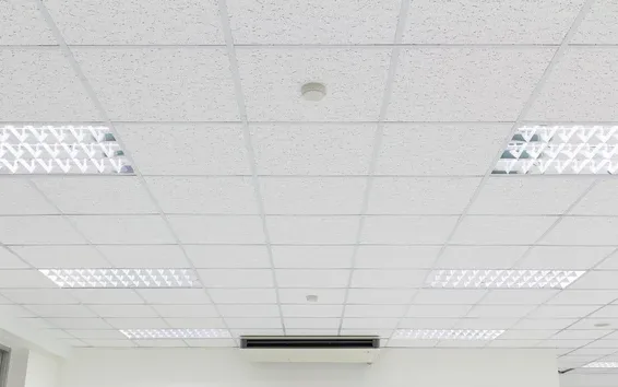 A suspended office ceiling grid with ceiling panels