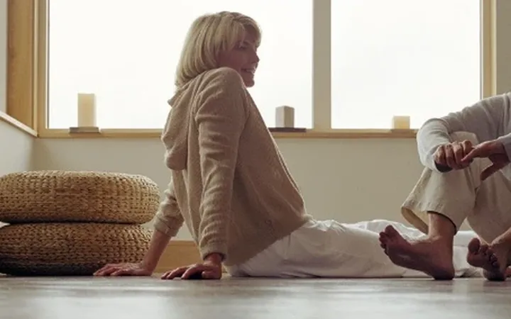 Two people sitting on a warm floor in a sunlit room